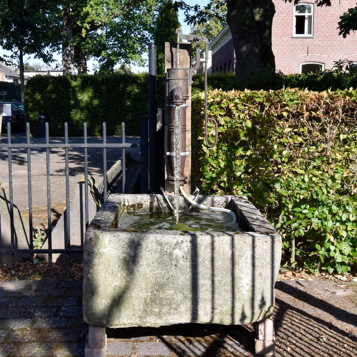 Wastrog-van-zandsteen-met-waterpomp