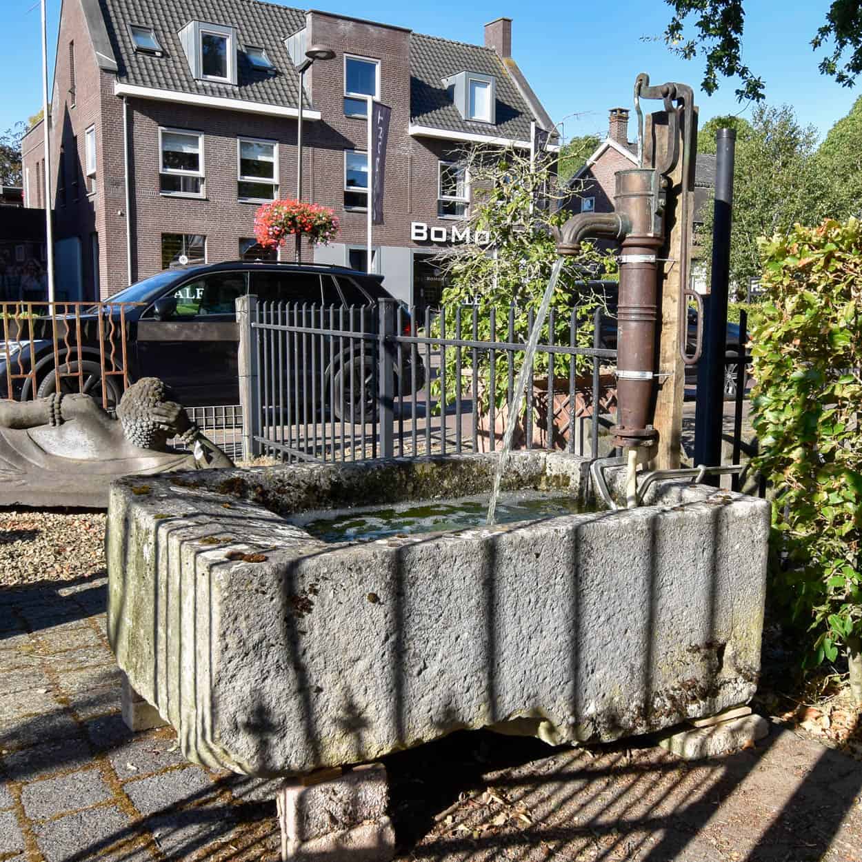 Wastrog-van-zandsteen-met-waterpomp