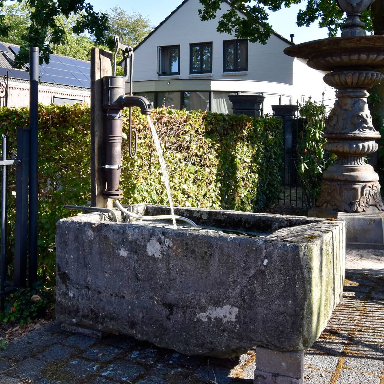 Wastrog-van-zandsteen-met-waterpomp