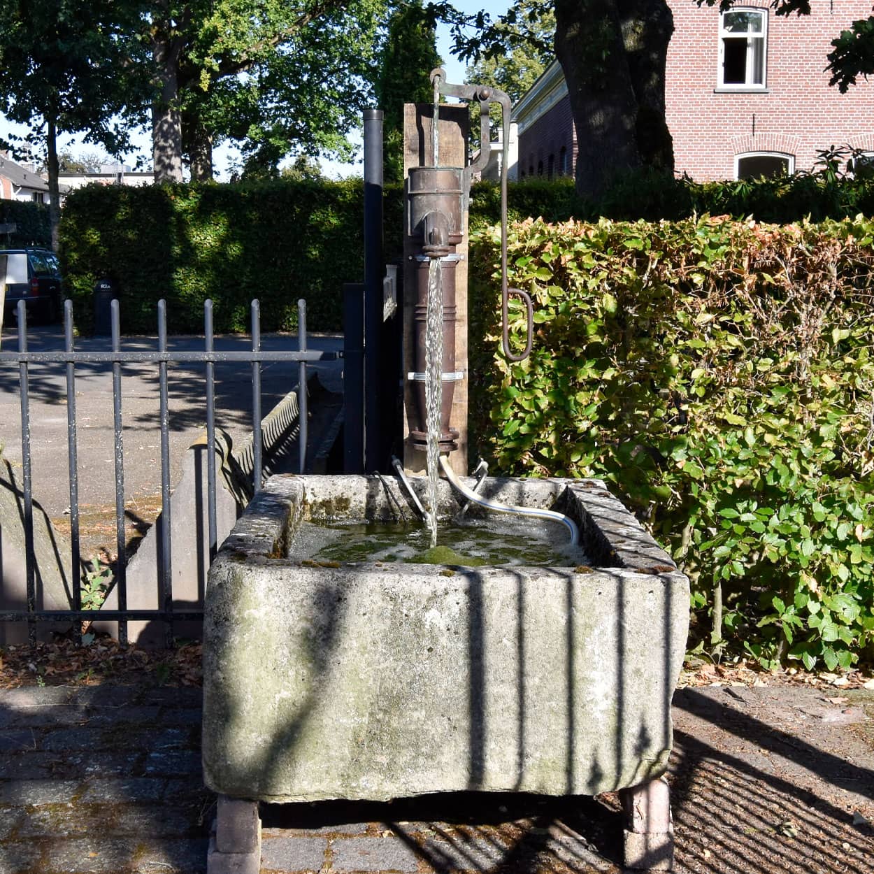 Wastrog-van-zandsteen-met-waterpomp