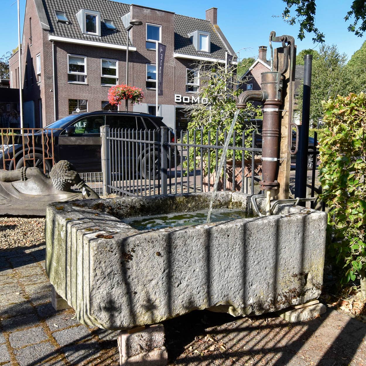 Wastrog-van-zandsteen-met-waterpomp