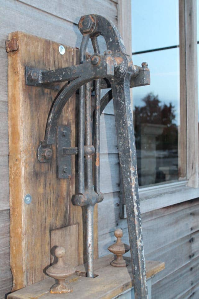 Zeer-mooie-unieke-waterpomp-met-mooie-bak-op-bord.-staat-bij-oude-zagerij